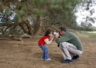 Man is trying to photograph a little girl