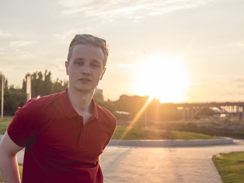 Portrait Of Beautiful Trendy Man Wearing Red Top And Sunglasses Outdoor During Sunset