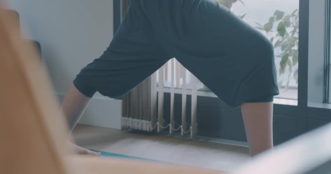 Young woman doing yoga in city apartment