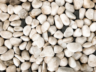Smooth and rounded sea pebbles texture. Sea pebbles background with white and black stones