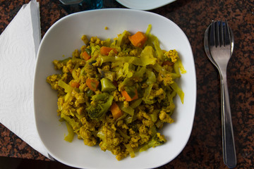 Mixed vegetables dish from top with silver spoon, for and paper napkin on the sides. Carrots, cauliflower and broccoli. Healthy eating, vegetarian concept