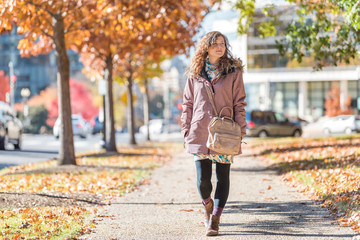 Young happy woman walking on sidewalk street in Washington DC, USA United States legs in alley of...