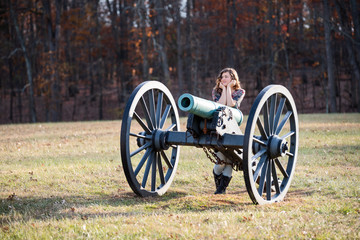 Young woman standing by old cannon in Manassas National Battlefield Park in Virginia where Bull Run...