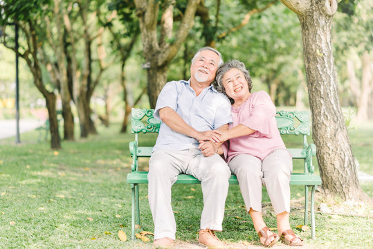 Happy Senior couple sitting on the bench in the park