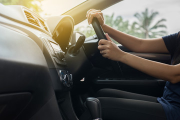 Hands of female driver on steering wheel,Woman driving a car on road