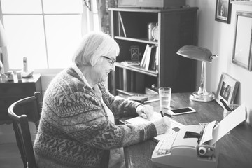 Senior woman writing on a paper