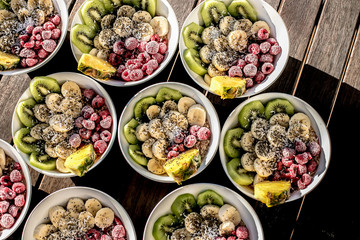 bowls with healthy breakfast food on wooden background