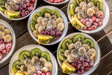bowls with healthy breakfast food on wooden background