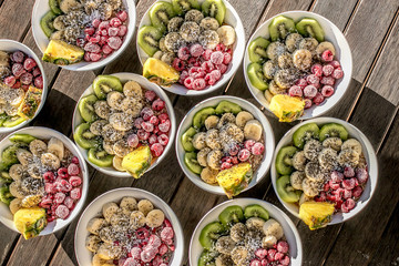 bowls with healthy breakfast food on wooden background
