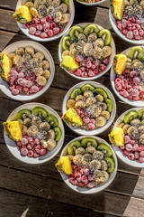 bowls with healthy breakfast food on wooden background