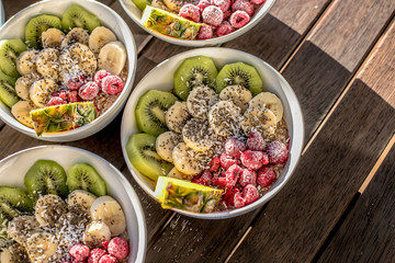 bowls with healthy breakfast food on wooden background