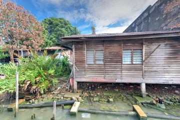 Close-up old shack slum house near Malacca river. Old wooden hut on stiltson the bank of river in...