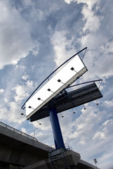 Blank billboard on a freeway overpass against dramatic cloudy blue sky