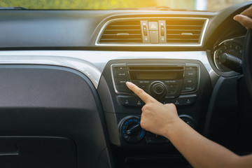 Hand woman driver turning car radio system