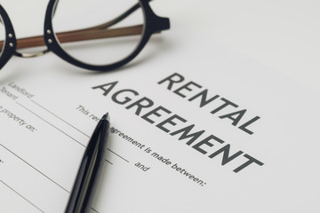 Obraz premium Property or real estate, house and home concept, pen and eyeglasses on rental agreement printed document, ready to sign contract