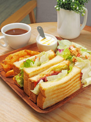 Duck meat sandwich with salad, fries and yogurt on the wooden plate