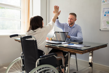 Disabled Businesswoman Giving High Five To Her Partner