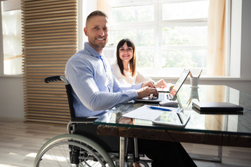 Smiling Disabled Businessman Working On Laptop