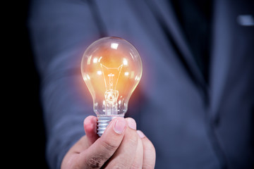businessman hand holding light bulb , idea and technology concept