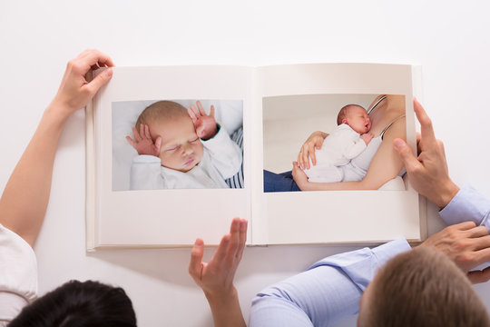 Couple Looking At Baby's Photo Album