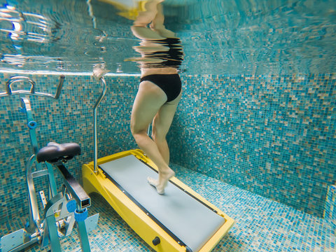 Young woman jogging on an underwater treadmill