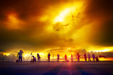 Fototapeta premium group of photographers silhouette watching sunset