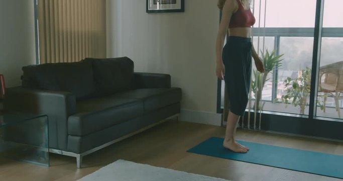 Young woman doing yoga at home in her city apartment