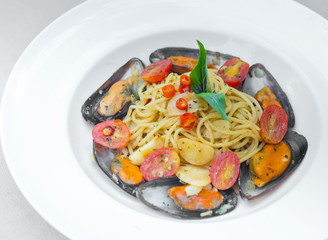 Pasta spaghetti with mussel and tomatoes isolated on white plate