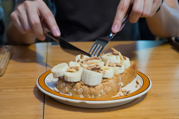 Whole wheat bread with banana slices on plate in hand,dessert