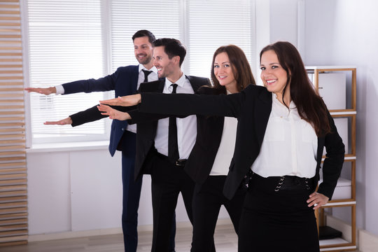 Businesspeople Doing Exercise With Hands Outstretched