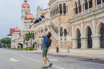 Dad and son on background of Sultan Abdul Samad Building in Kuala Lumpur, Malaysia. Traveling with...