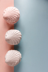 Homemade marshmallows, zephyr on a pink-blue pastel color background.