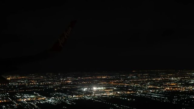 Bangkok, Thailand- Jun 4, 2018. Thai Airasia airline flight FD 3010 fly from Phuket (HKT) to Donmuang Bangkok (DMK) is landing. View from window seat Illuminated city in dark night. 
