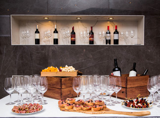 the table is covered with appetizers and glasses for wine