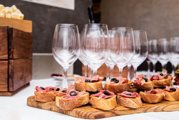 Snacks with ham on the banquet table and glasses of wine