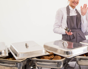 the waiter of the catering service serves a buffet table