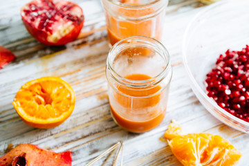 Pomegranate and orange juice is poured on a jar glas. Fruts pomegranate seeds and orange cut n half...