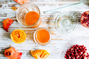 Pomegranate and orange juice is poured on a jar glas. Fruts pomegranate seeds and orange cut n half...