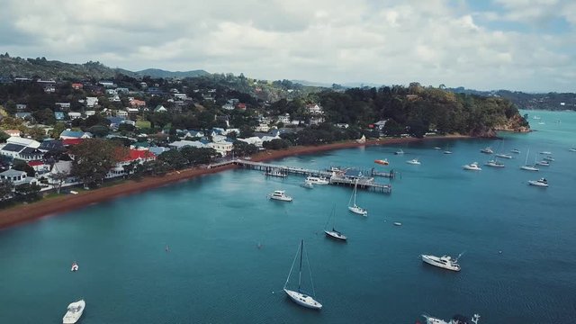 Aerial pan, beautiful beach side town Russell in the bay of islands in New Zealand, boats in the harbor, 4k.