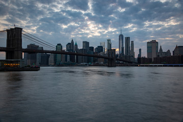 Fototapeta na wymiar New York skyline at dusk with the Brooklyn Bridge in the foreground