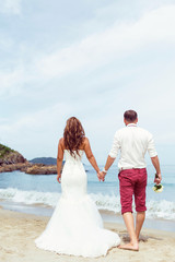 Fototapeta na wymiar Wedding couple on the beach. Back veiw