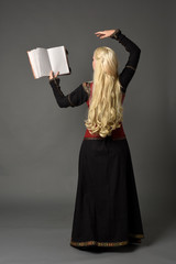  full length portrait of pretty blonde lady wearing  a red and black fantasy medieval gown, holding...