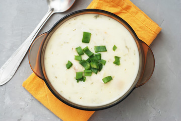 Cream Soup with Chicken Meat and Bread Crackers Croutons Orange Napkin Gray Textured Background
