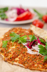 Turkish pizza with meat - lahmacun on a wooden table. Vertical