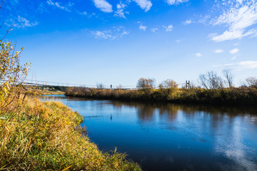 Fototapeta premium Bridge over the river and the autumn nature around