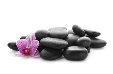 Pile of spa stones and flower on white background