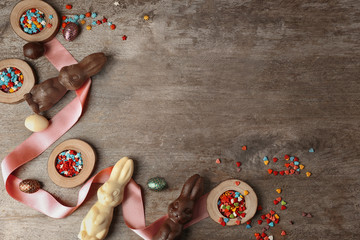 Beautiful Easter composition with chocolate bunnies and sprinkles on wooden background