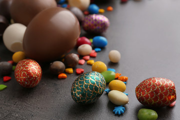 Chocolate Easter eggs with colorful sprinkles and candies on table