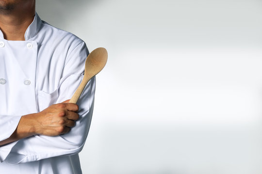 Chef with a wooden spoon background with space for text