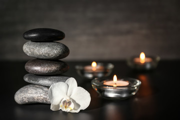 Fototapeta na wymiar Beautiful composition with spa stones on black table